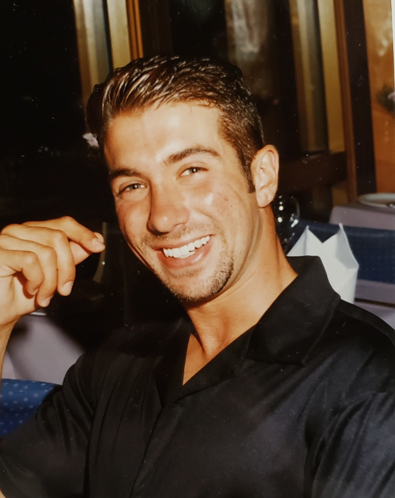 Brandon in his twenties, smiling at a dinner table