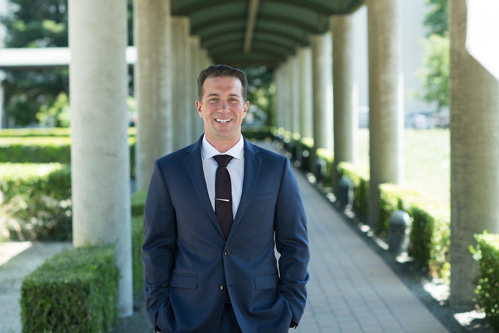 Brandon Frere in a navy suit outside a colonnade
