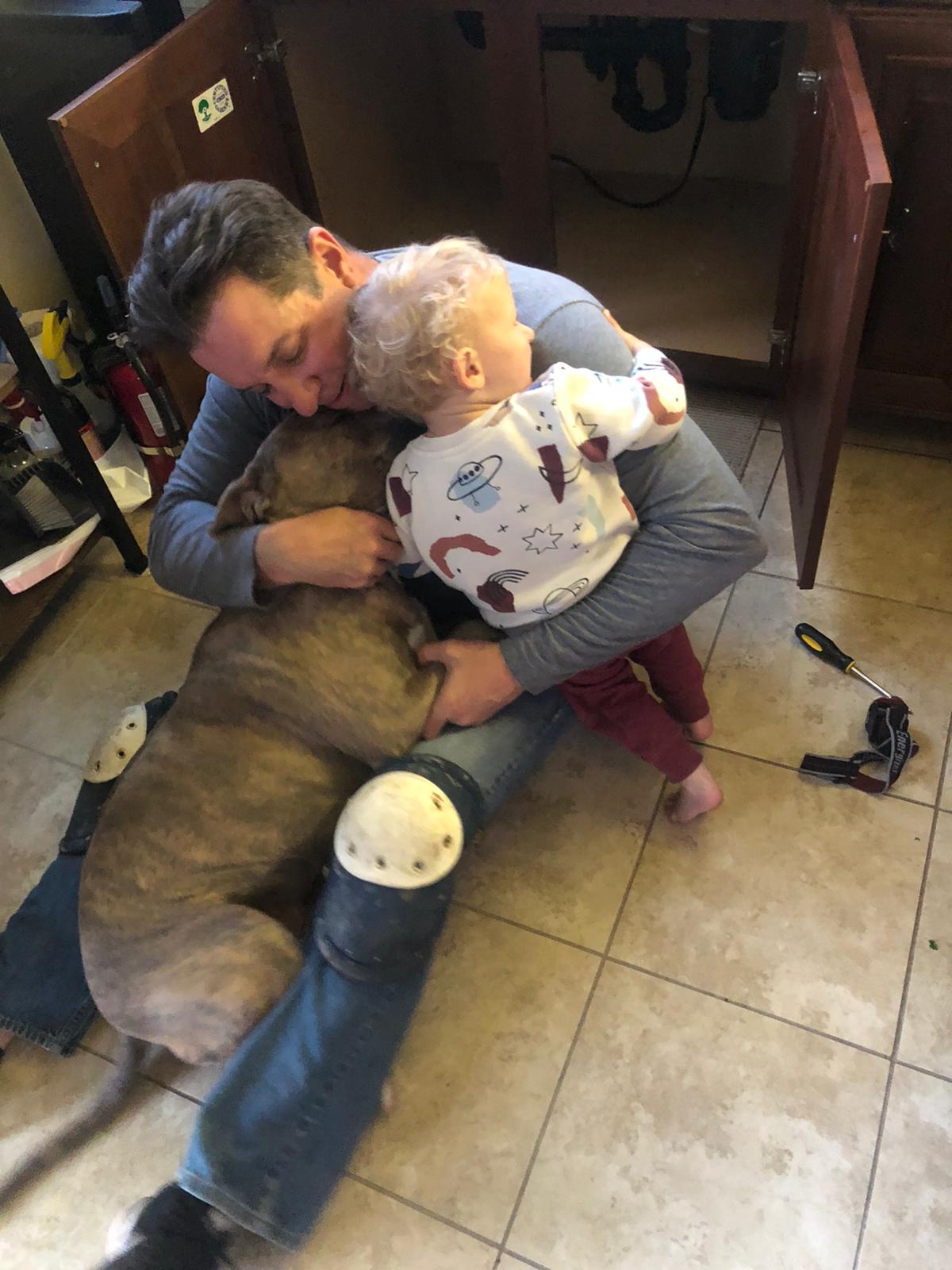 On the kitchen floor with his son and their dog
